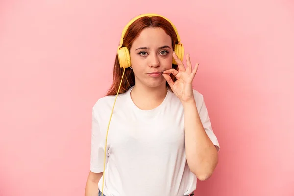 Mujer Caucásica Joven Escuchando Música Aislada Sobre Fondo Rosa Con —  Fotos de Stock