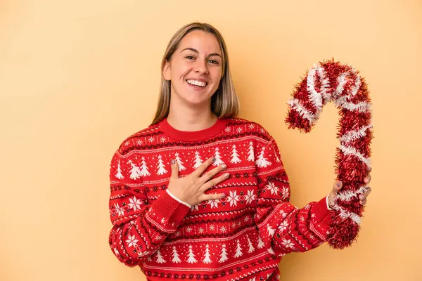 Young Caucasian Woman Holding Big Christmas Stick Isolated Yellow Background — Stock Photo, Image