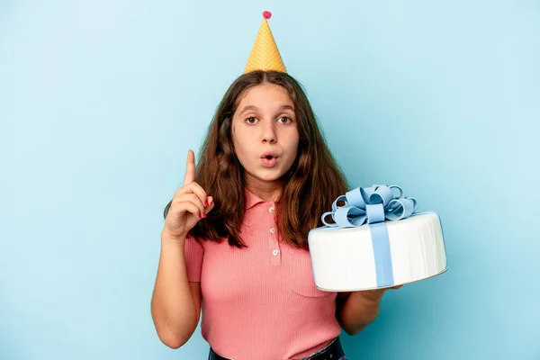 彼女の誕生日を祝う小さな白人の女の子いくつかの素晴らしいアイデアを持っている青い背景に隔離されたケーキを保持します 創造性の概念 — ストック写真
