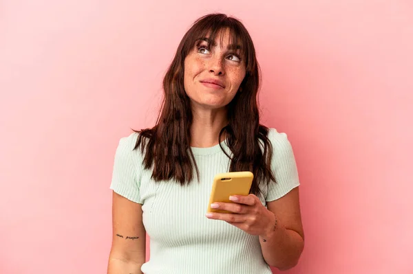 Junge Argentinierin Hält Ein Handy Isoliert Auf Rosa Hintergrund Und — Stockfoto