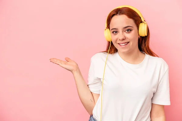 Jonge Blanke Vrouw Luisteren Naar Muziek Geïsoleerd Roze Achtergrond Tonen — Stockfoto