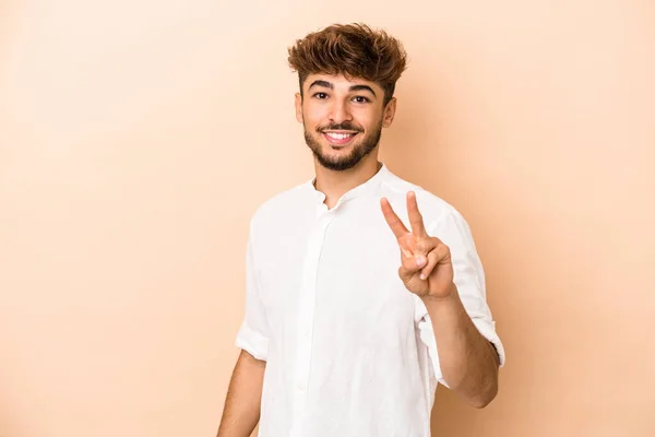 Jonge Arabische Man Geïsoleerd Beige Achtergrond Met Overwinningsteken Brede Glimlach — Stockfoto