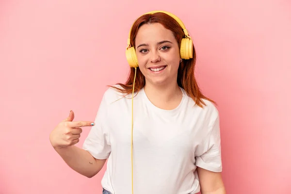 Young Caucasian Woman Listening Music Isolated Pink Background Person Pointing — Stock Photo, Image