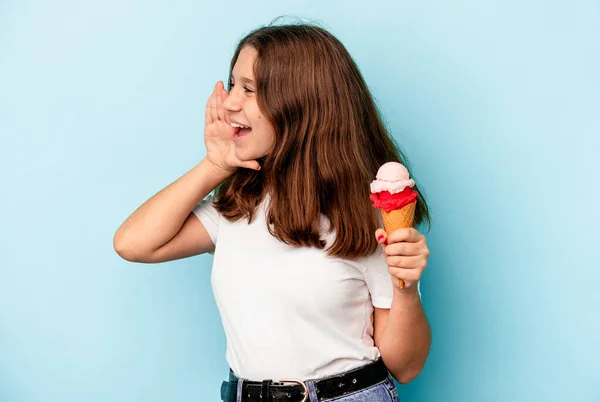 小女孩吃着用蓝色背景隔开的冰淇淋 大喊着 手牵着手掌靠近张开的嘴 — 图库照片