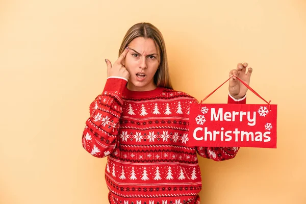 Mladá Běloška Drží Veselé Vánoční Plakát Izolované Žlutém Pozadí Ukazuje — Stock fotografie