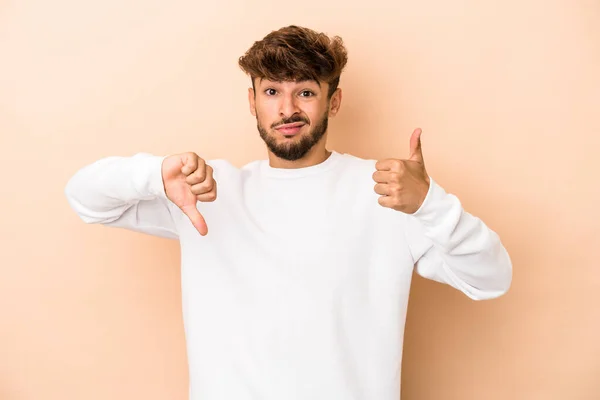 Young Arab Man Isolated Beige Background Showing Thumbs Thumbs Difficult — стоковое фото