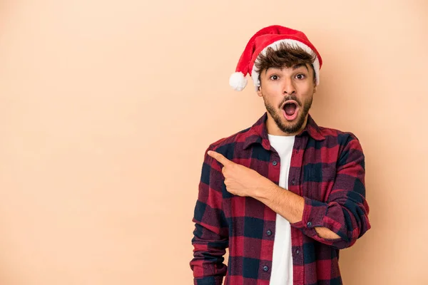 Young Arab Man Celebrating Christmas Isolated Beige Background Pointing Side — Photo