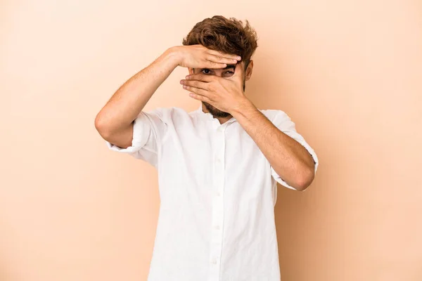 Young Arab Man Isolated Beige Background Blink Camera Fingers Embarrassed — Stockfoto