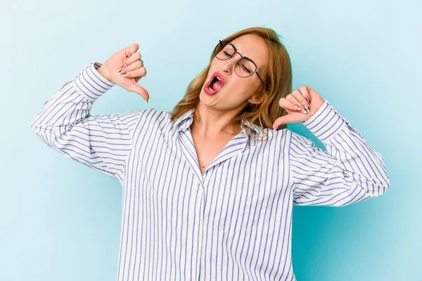 Mavi arka planda izole genç beyaz kadın gururlu ve kendinden emin hissediyor, örnek olarak..