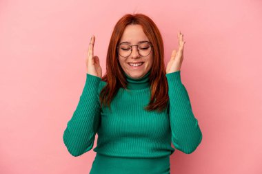 Pembe arka planda izole edilmiş beyaz bir kadın neşeli bir şekilde gülüyor. Mutluluk kavramı.