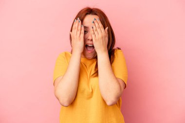 Pembe arka planda izole edilmiş beyaz bir kadın yüzünün yarısını palmiye ile örterek eğleniyor..