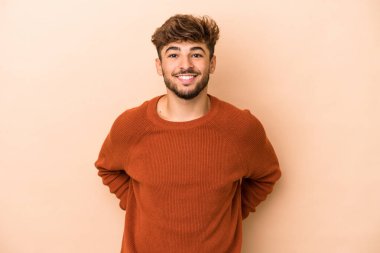 Young arab man isolated on beige background happy, smiling and cheerful.