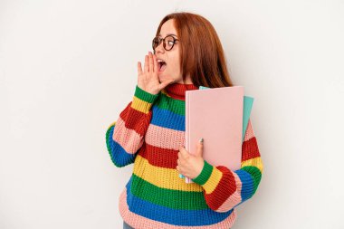 Young student caucasian woman isolated on white background shouting and holding palm near opened mouth.
