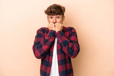 Young arab man isolated on beige background biting fingernails, nervous and very anxious.