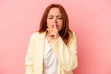 Young caucasian woman isolated on pink background keeping a secret or asking for silence. clipart