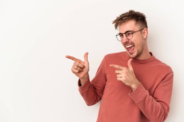 Beyaz arka planda izole genç beyaz adam parmak uzakta, gülüyor ve kaygısız.