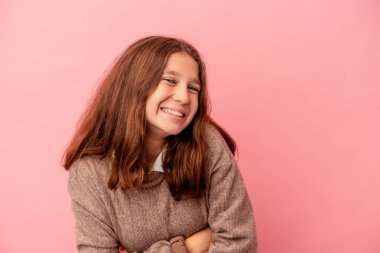 Küçük beyaz kız pembe arka planda izole edilmiş gülüyor ve eğleniyor..