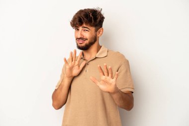 Genç melez adam gri arka planda izole edilmiş, tiksinti gösteren birini reddediyor..