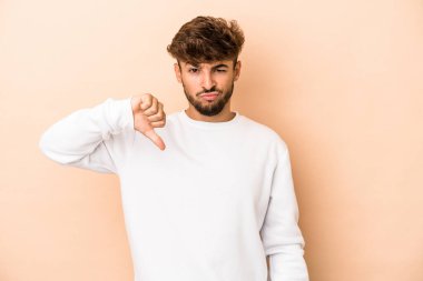 Young arab man isolated on beige background showing thumb down, disappointment concept.