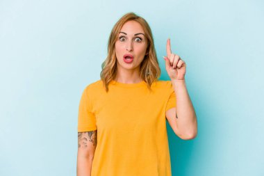 Kafkasyalı genç bir kadın mavi arka planda izole edilmiş. Harika bir fikri var, yaratıcılık kavramı..