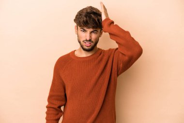 Young arab man isolated on beige background forgetting something, slapping forehead with palm and closing eyes.