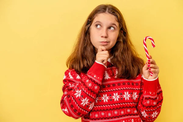 Piccola Ragazza Caucasica Con Bastone Natale Isolato Sfondo Giallo Guardando — Foto Stock