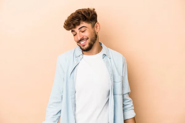 Young Arab Man Isolated Beige Background Laughs Closes Eyes Feels — стоковое фото