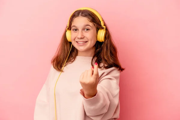 Pequeña Chica Caucásica Escuchando Música Aislada Sobre Fondo Rosa Señalándote — Foto de Stock
