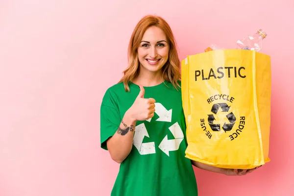 Young Caucasian Woman Recycled Plastic Isolated Pink Background Smiling Raising — стоковое фото