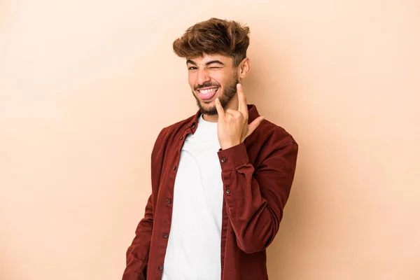 Young Arab Man Isolated Beige Background Showing Rock Gesture Fingers — стоковое фото