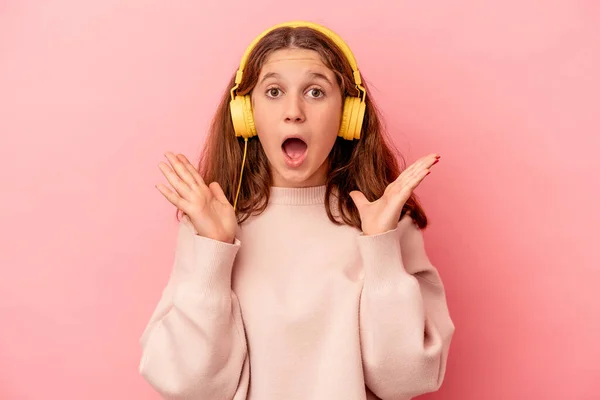 Pequeña Chica Caucásica Escuchando Música Aislada Sobre Fondo Rosa Sorprendida — Foto de Stock