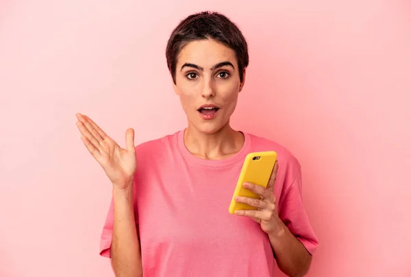 Молодая Белая Женщина Мобильным Телефоном Розовом Фоне Удивлена Шокирована — стоковое фото