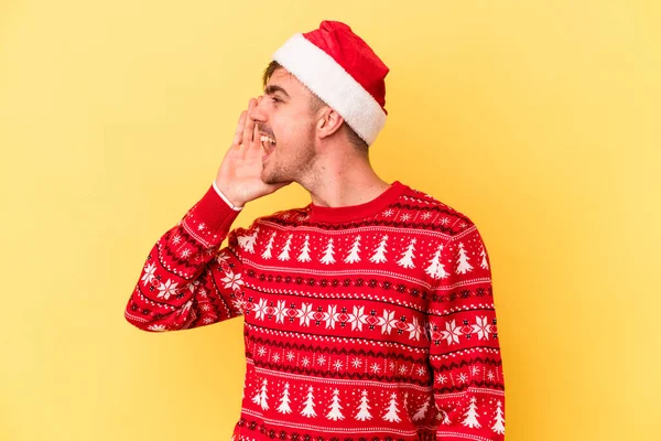 若いですCaucasian男祝いますクリスマス孤立オン黄色の背景叫びと保持ヤシ近くにオープン口 — ストック写真
