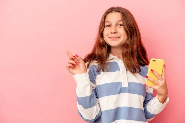 Mała Kaukaska Dziewczyna Trzyma Telefon Komórkowy Odizolowany Różowym Tle Uśmiechając — Zdjęcie stockowe