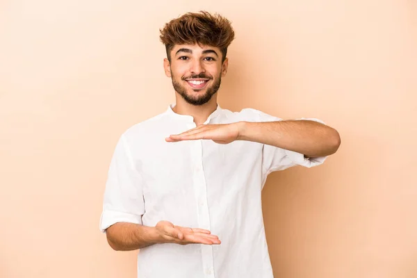 Young Arab Man Isolated Beige Background Holding Something Both Hands — Φωτογραφία Αρχείου