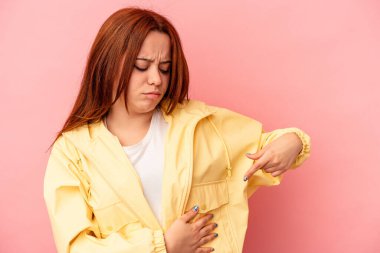 Pembe arka planda karaciğer ağrısı çeken, karnı ağrıyan beyaz bir kadın..