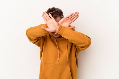 Beyaz arka planda izole genç beyaz adam iki kolu çapraz tutuyor, inkar kavramı.