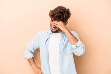 Genç Arap adam bej arka planda izole edilmiş neşeli gülüyor. Mutluluk kavramı.