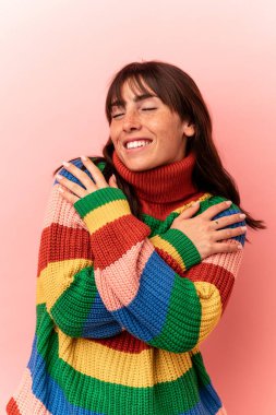 Arjantinli genç bir kadın pembe arka planda izole edilmiş.