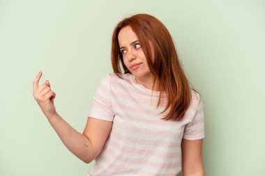 Yeşil arka planda izole edilmiş genç beyaz kadın sanki seni davet ediyormuş gibi seni işaret ediyor..