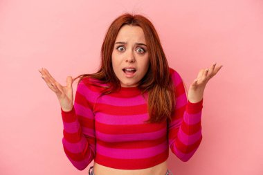 Pembe arka planda izole edilmiş genç beyaz kadın gökyüzüne haykırıyor, yukarı bakıyor, hayal kırıklığına uğramış..
