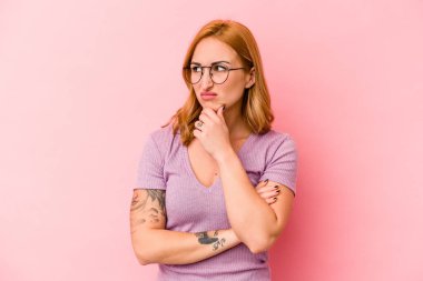 Pembe arka planda izole edilmiş genç beyaz kadın virüs veya enfeksiyon yüzünden boğazında ağrı hissediyor..