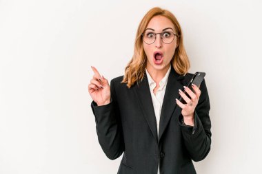 Young business caucasian woman holding mobile phone isolated on white background pointing to the side