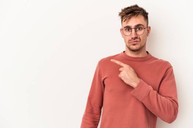 Beyaz arka planda izole edilmiş genç beyaz adam yan tarafı işaret ediyor