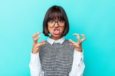 Mavi arka planda izole edilmiş genç melez kadın gergin ellerle çığlık atıyor..