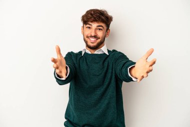 Genç melez adam gri arka planda izole edilmiş hoş bir ifade sergiliyor..