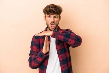 Young arab man isolated on beige background showing a timeout gesture.