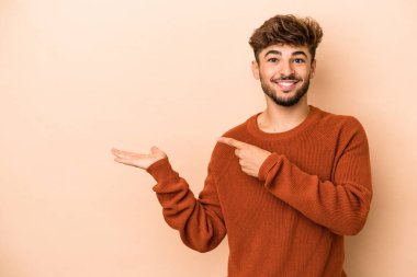 Genç Arap, bej arka planda izole edilmiş..