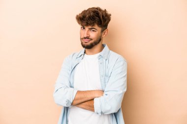 Young arab man isolated on beige background unhappy looking in camera with sarcastic expression.