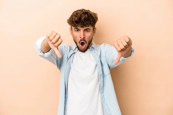 Hombre Árabe Joven Aislado Sobre Fondo Beige Mostrando Pulgar Hacia —  Fotos de Stock